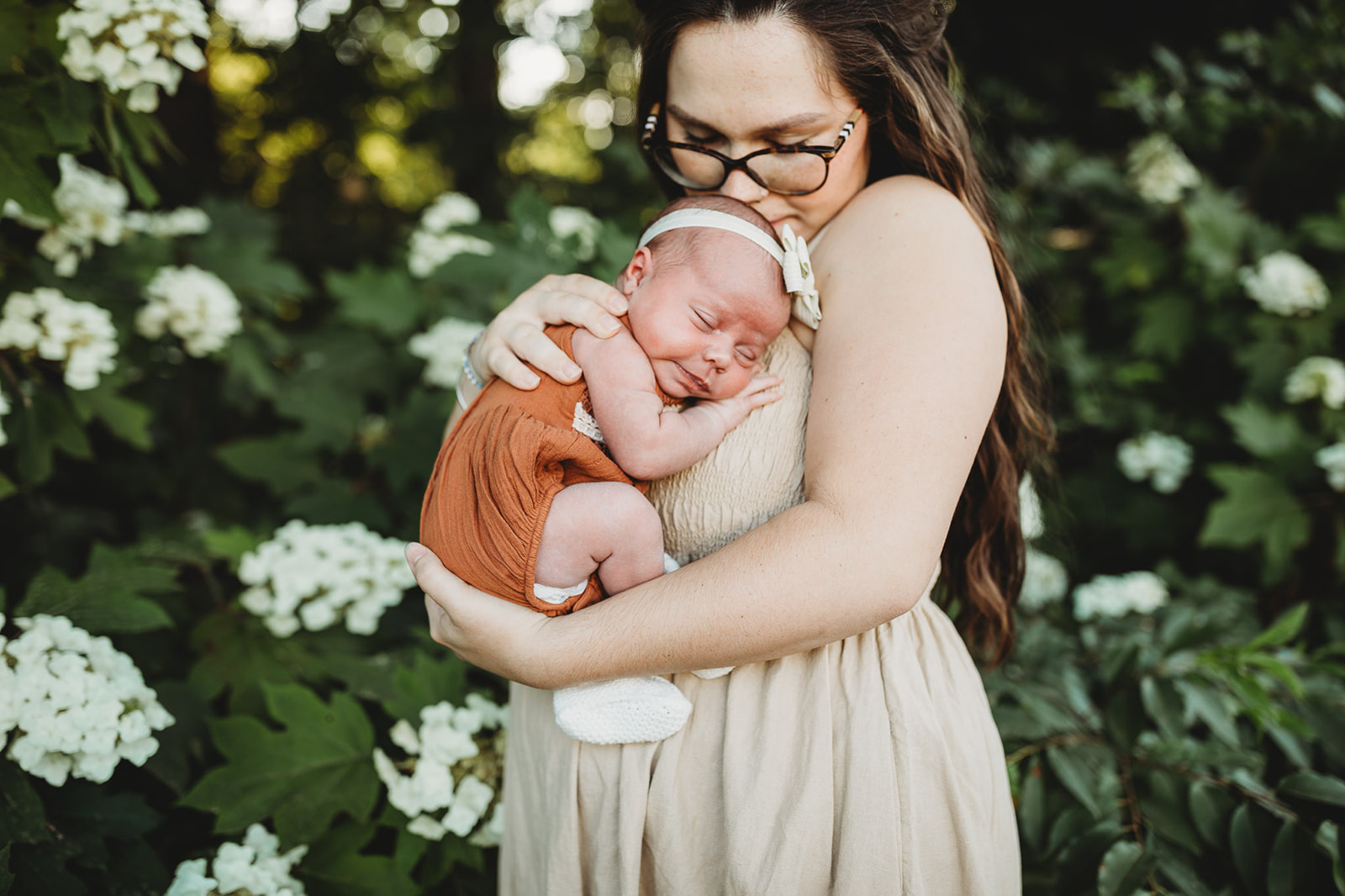 An infant girl sleeps on mom's chest while they explore a flower garden thanks to 3D Ultrasound Harrisonburg, VA