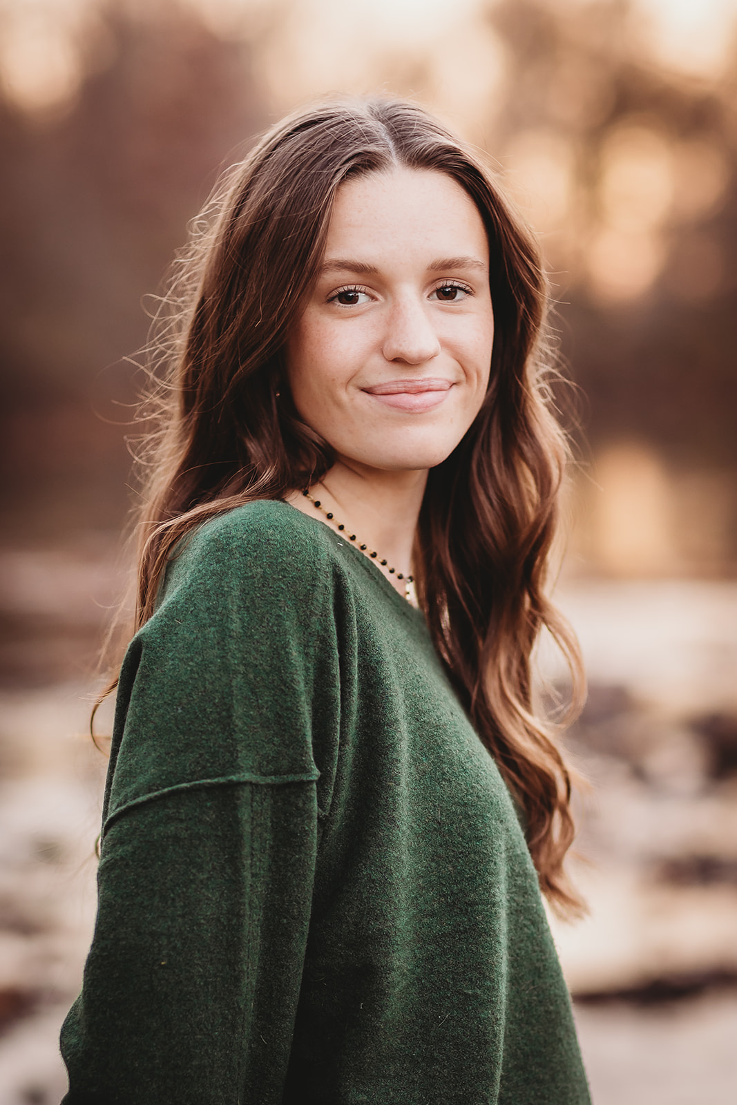 A teenage girl in a green sweater smiling after shopping at Clothing Stores in Harrisonburg, VA