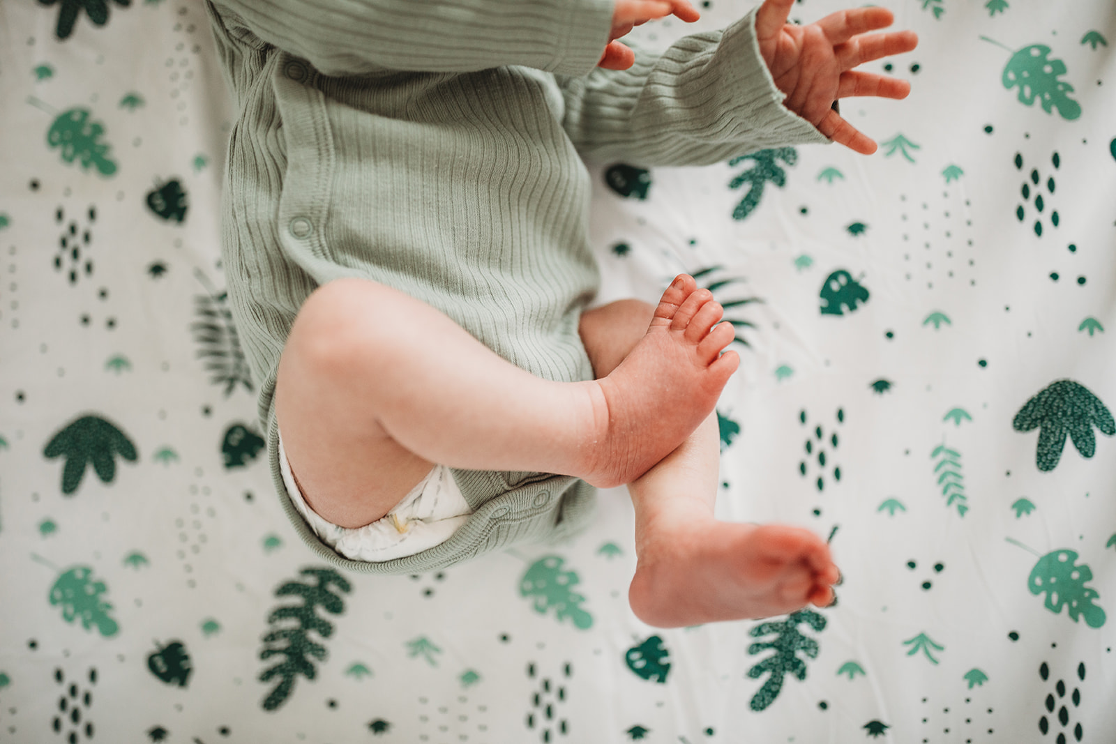 Details of a newborn baby's feet while laying in a crib