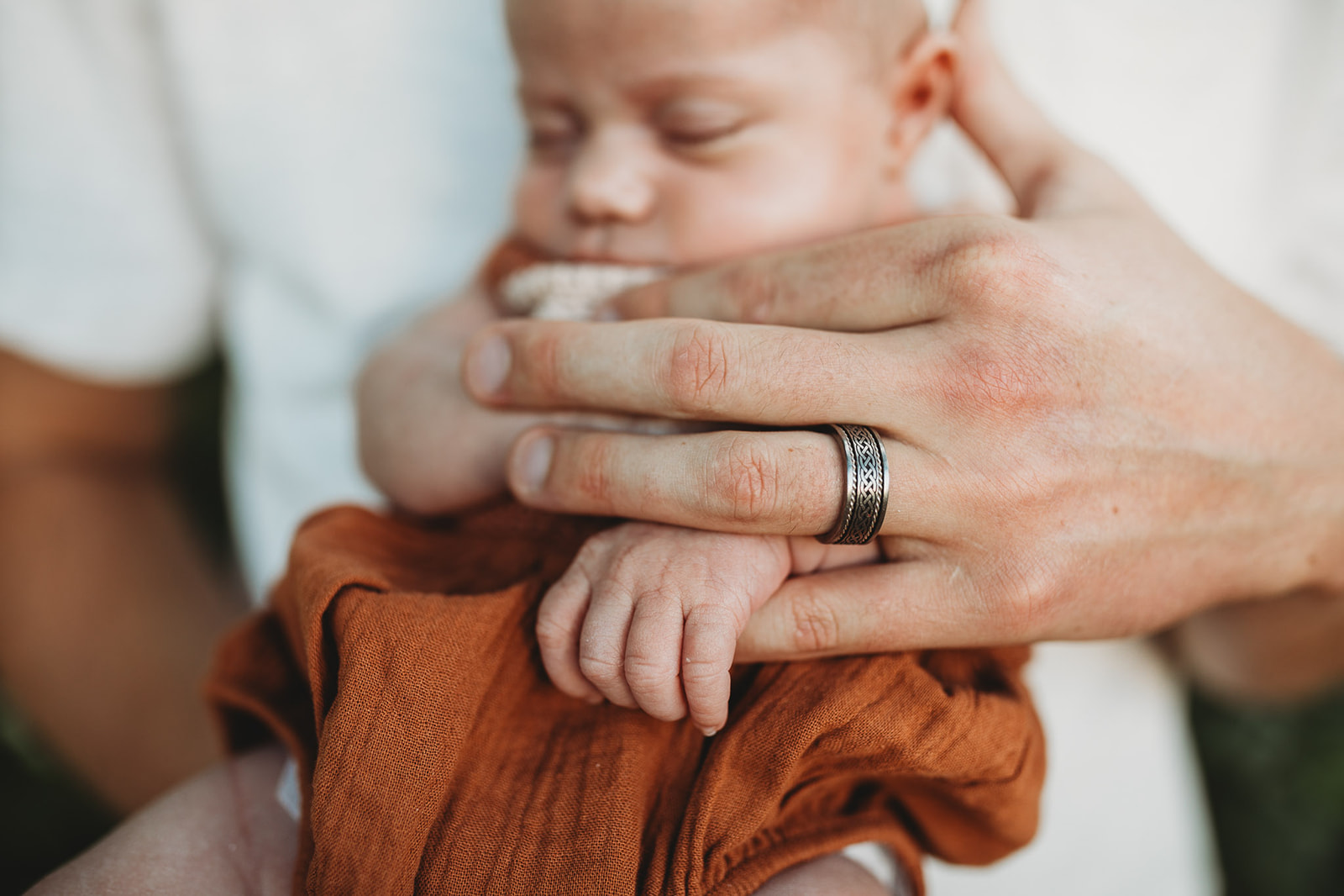 Details of a newborn baby holding dad's finger